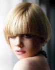 Blond hair cut into an assymetrical style with a plumb line