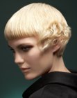 Short blonde hairdo with curls along the side of the face