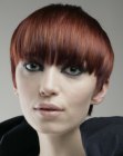 Short red hair with bangs that fall over the eyebrows