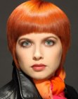 Short precision haircut with a helmet shape and an orange hue