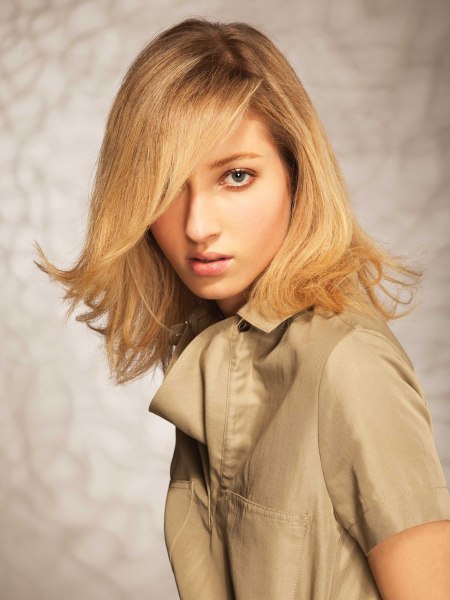 Blonde shoulder long bob with a side part and flipped out ends