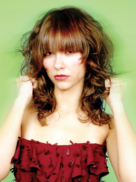Lonog hairstyle with a contrast of curls and a thick straight fringe