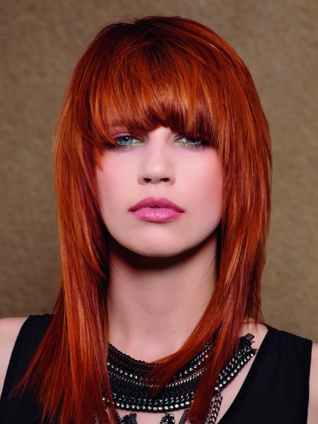 Long red hair with bangs and a tapered cutting line