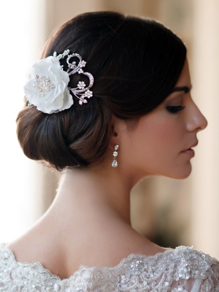 Braided chignon and a bridal headpiece with a flower