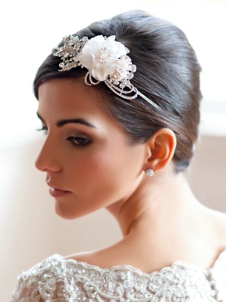 Wedding updo with a silken rose and ivory faux pearl accents