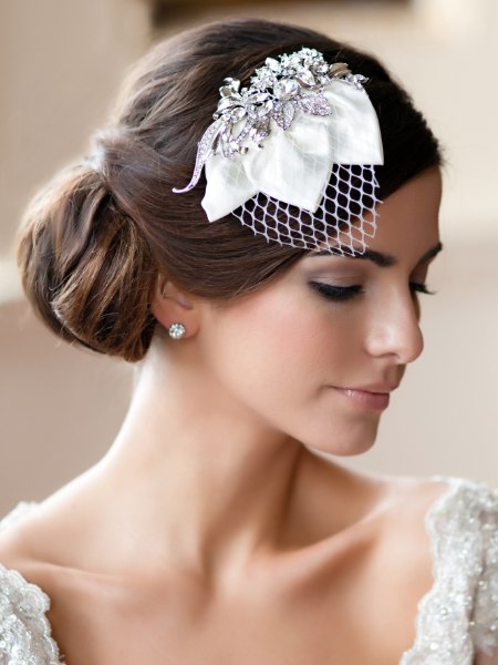 Soft chignon and a vintage headpiece with a tiny veil