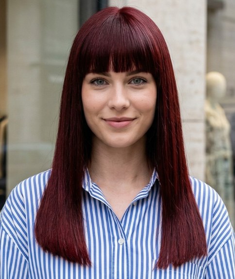 Long, burgundy-red hair with a full fringe