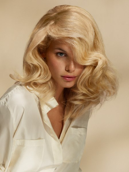 Long blonde hair with waves and a sporty silk blouse