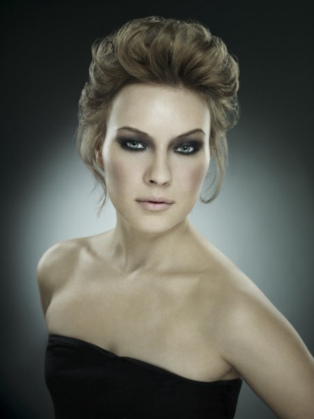 Curled updo with the hair styled toward the back