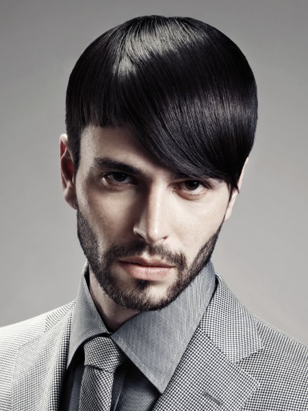 Man with sleek hair and a stubbly beard