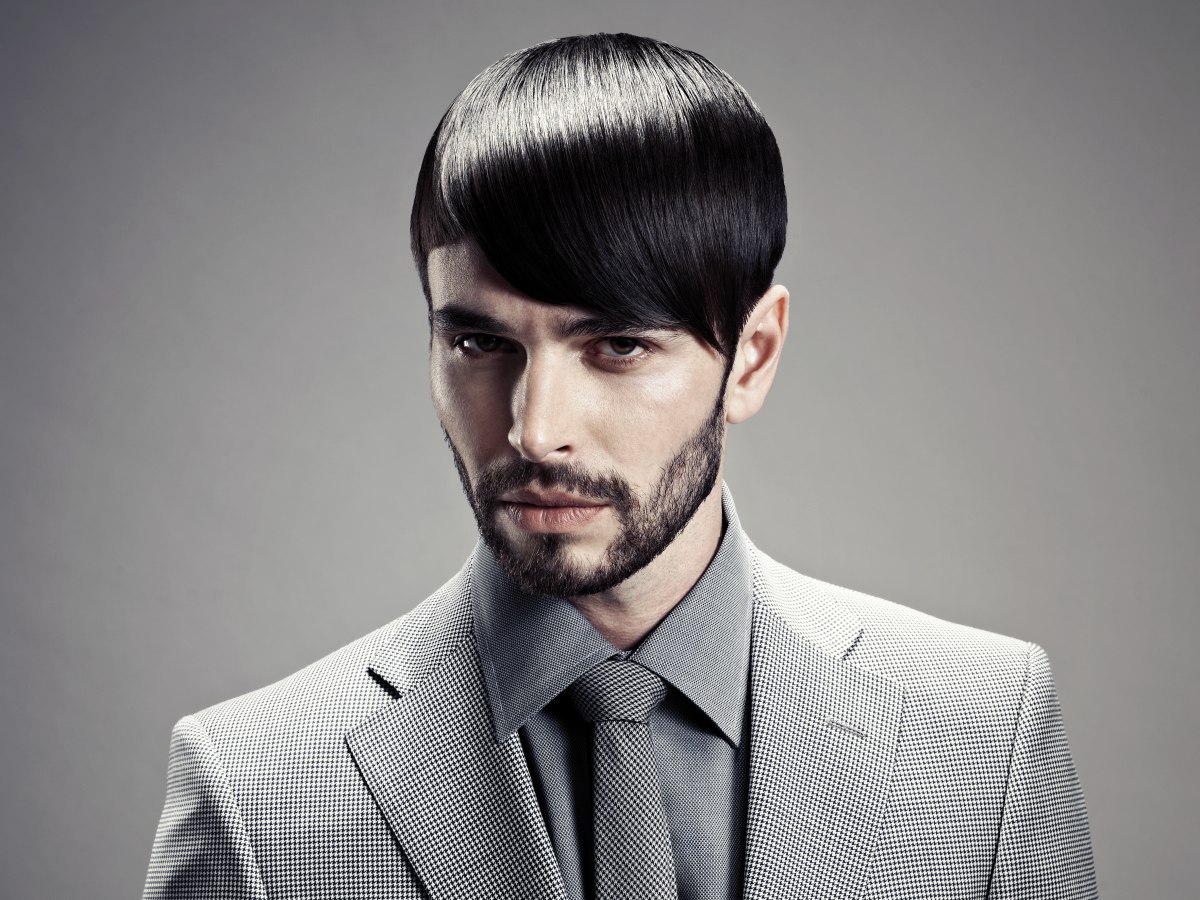 Haircut with sleek styling for a man with a stubbly beard