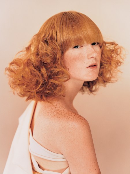 Red hair with large curls and 70s influences