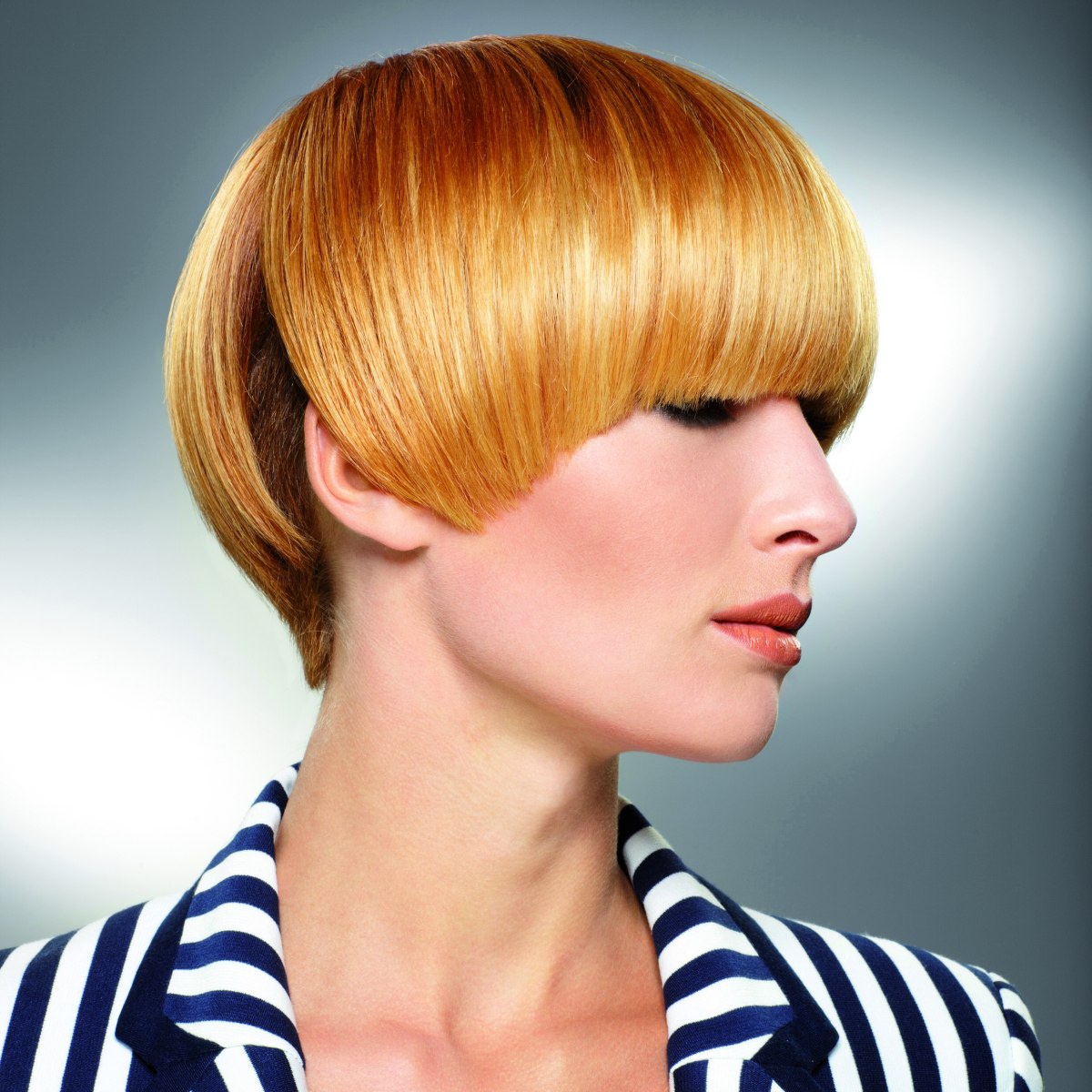 Short bowl haircut with a fringe that throws a shadow over 