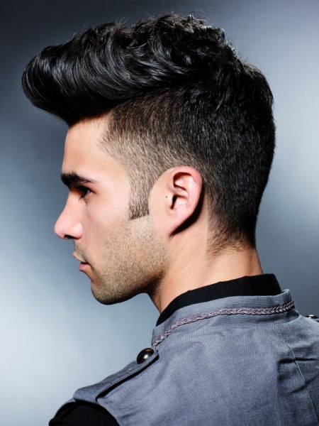 Side view of a male haircut with buzzed short sides and a quiff