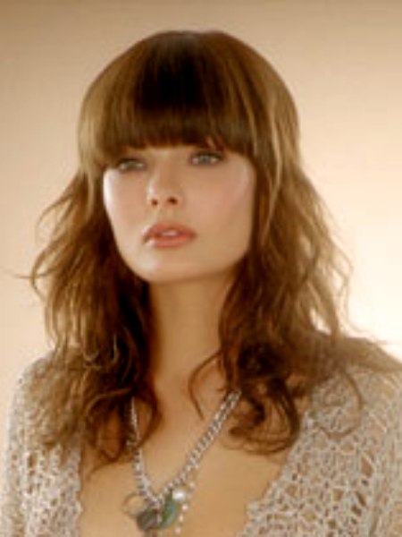 Long brown hair with bangs that cuff the eyebrows