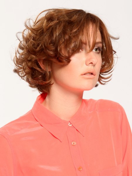 Short curly hairstyle with layers and a buttoned-up silk blouse