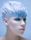 Short women's hair with buzzed sides and a blue hue