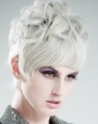 Short hair with large curls and a monochromatic silver color