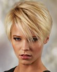 Flattering blonde pixie cut with short layers and long bangs
