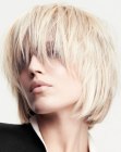Blonde bob with rounded edges and bangs that cover the eyes