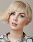 Short blonde asymmetrical bob with razor cut bangs