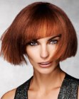 Red hair cut to a modern short bob with diagonal bangs