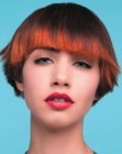 Cool short hairstyle with temple-to-temple bangs and a rich red hair color