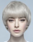 Short hairdo with thick bangs and a softened hairline along the face