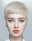 Very short blonde pixie cut with short arched bangs