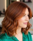 Shoulder-length auburn hair with waves and copper highlights