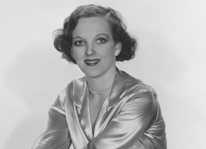 Short 1930s hairstyle and a shiny silk blouse