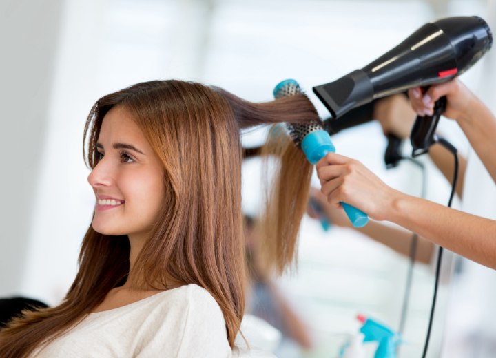 Stylist while blow drying long hair