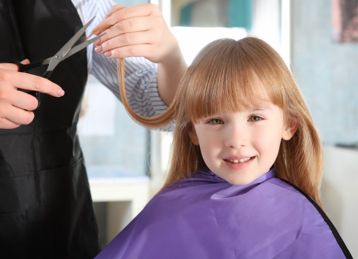 A little girl getting her hair cut