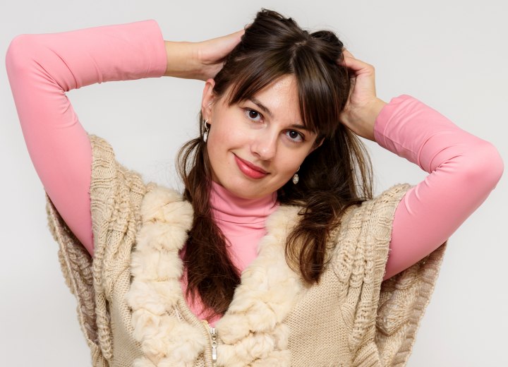 Young woman wearing a pink turtleneck and considering a new haircut