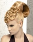 Sleek hairdo with a topknot and spiraling curls