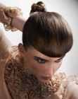 Updo with a tightly-woven knot and blunt bangs