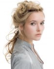 Romantic hairstyle with curls and a variety of knots and twists