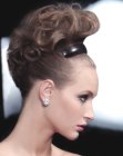 Hair up style with dense curls and a barrette