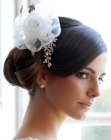 Hairstyle with a low bun and a headpiece with a white rose