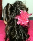 Cascading curls and a flower hair accessory