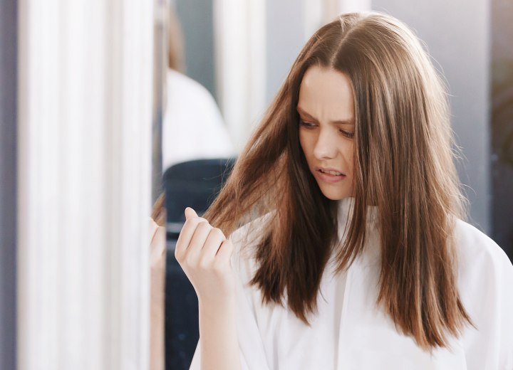 Unhappy woman who has damaged hair ends