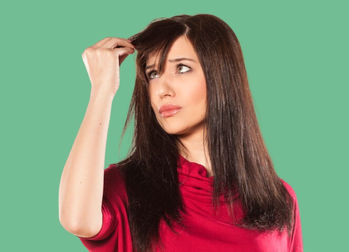 Young woman checking the growth of her hair