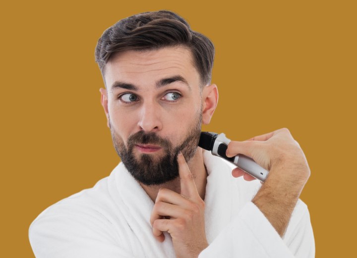Man who is trimming his beard