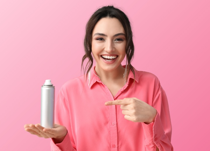 Donna con lo shampoo secco aerosol in mano
