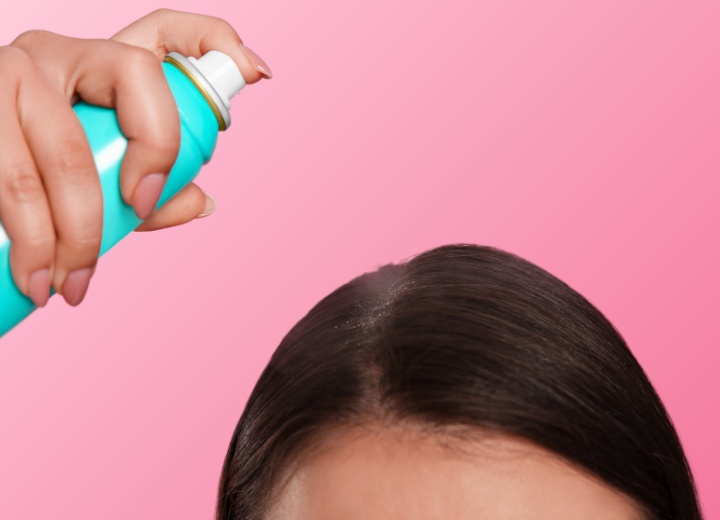 Donna che applica lo shampoo secco sulle radici
