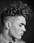 Men's hair with shaved sides and a curly quiff