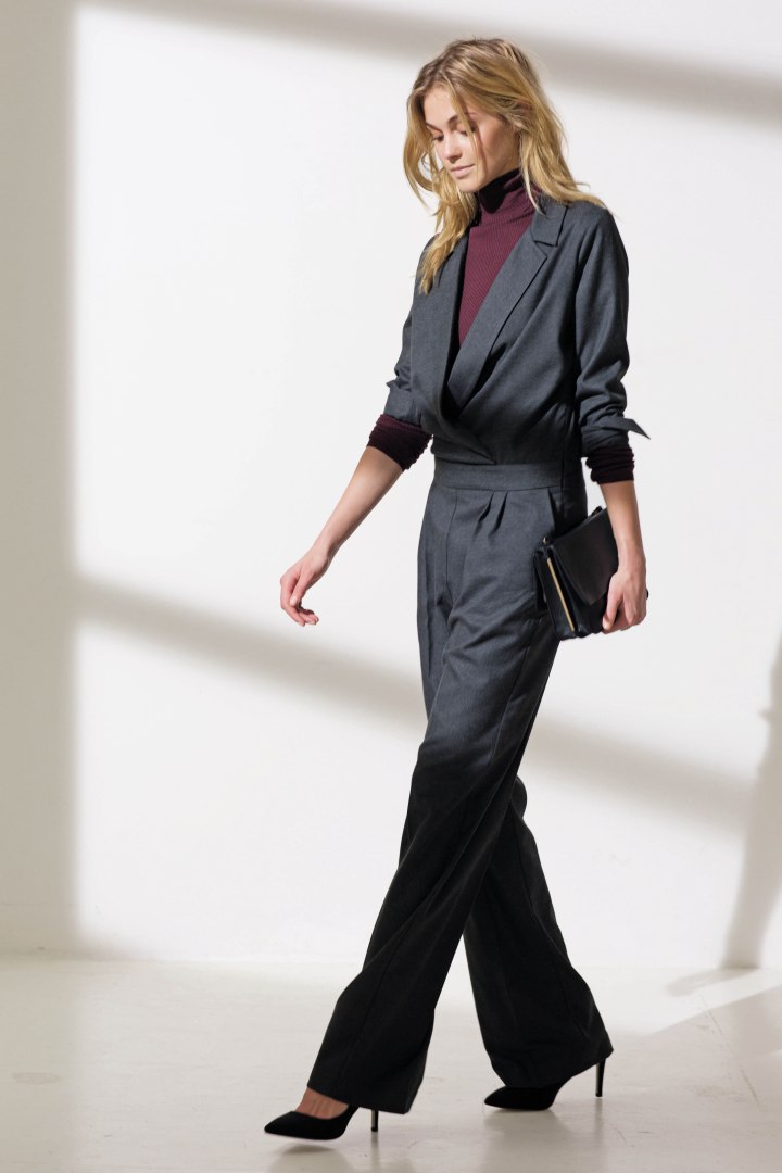 Purple turtleneck paired with a gray jumpsuit and black stilettos