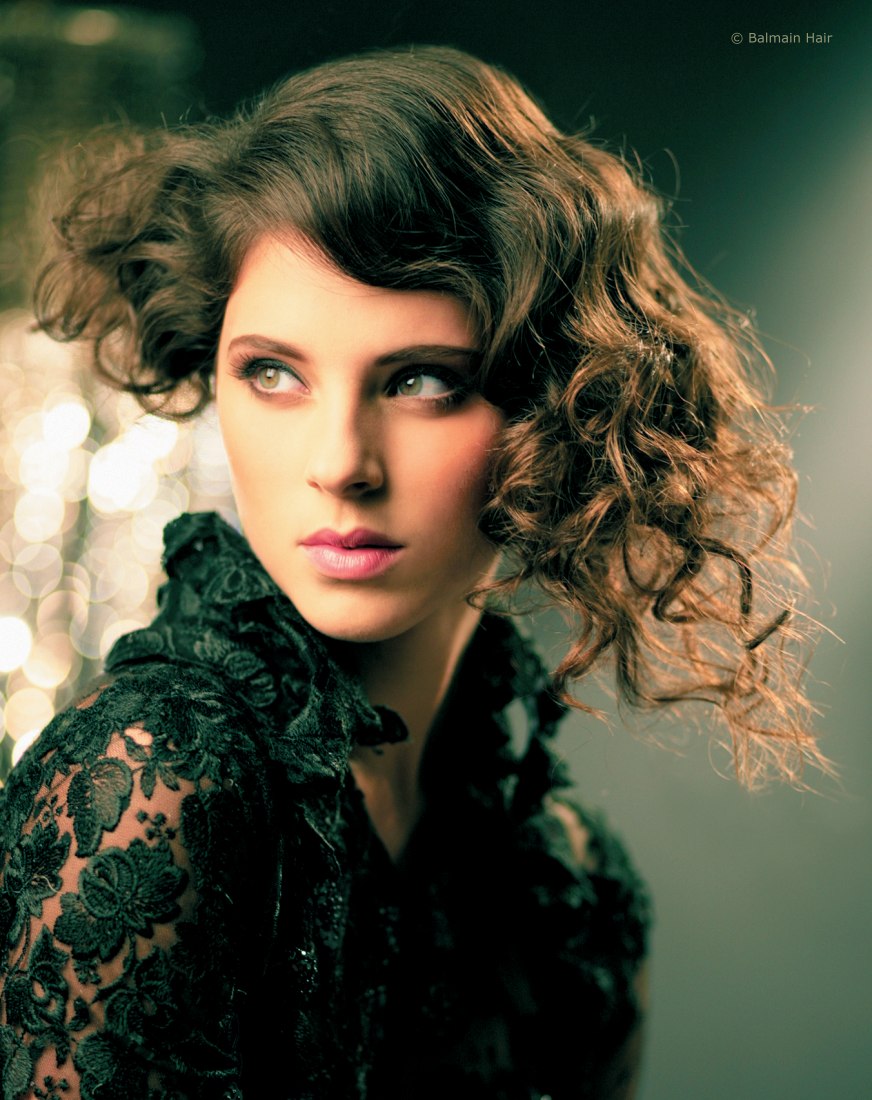 Short hairstyle with curls and added length on one side, created with hair  extensions
