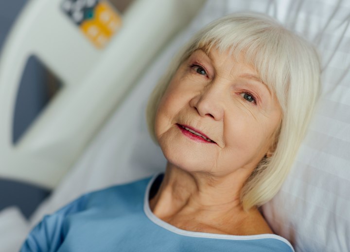 Bedridden patient with gray hair in a bob