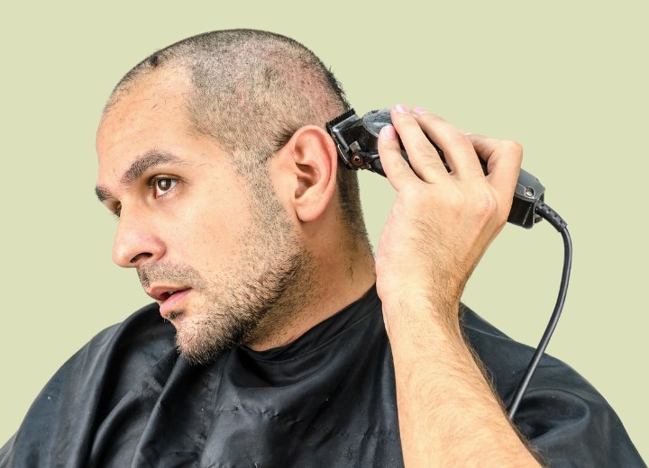 Man who is clipper cutting his own head